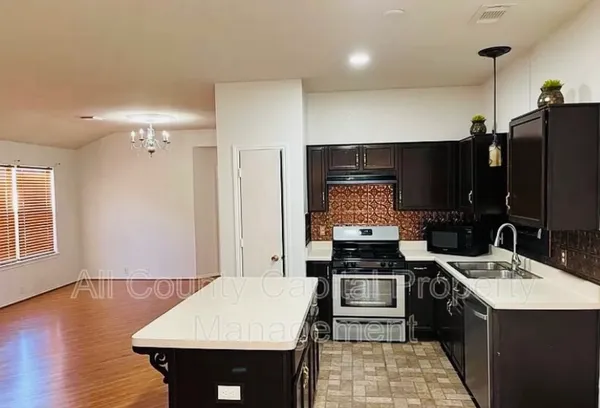 a kitchen with a sink appliances and cabinets