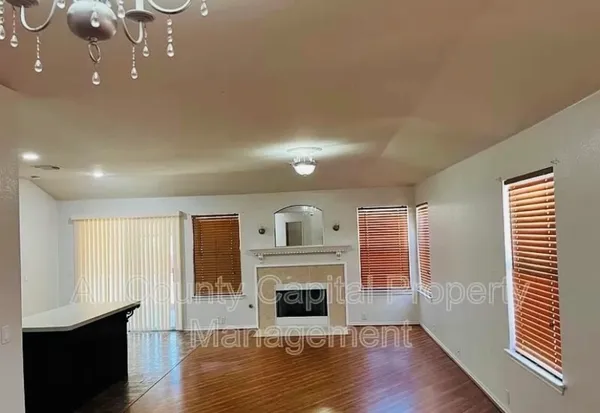 an empty room with windows and fireplace