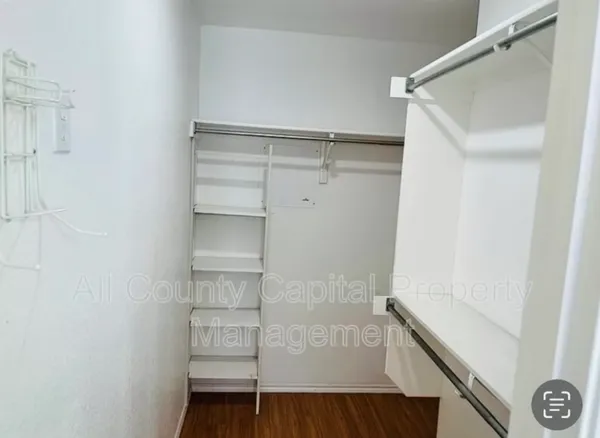 a view of walk in closet with empty racks
