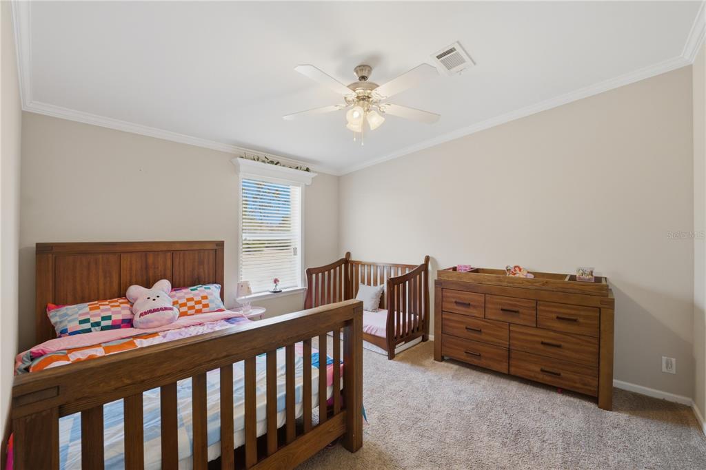 6844 Chad Jason Road St. Cloud, FL 34773 - Photo 25 of 59 a bedroom with a bed and a chandelier