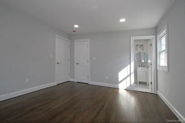 a bathroom with a granite countertop toilet a sink a mirror and shower
