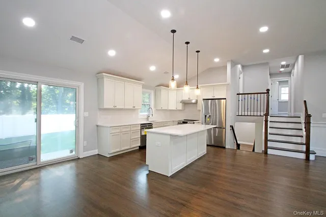 a large kitchen with a lot of counter space and a wooden floor