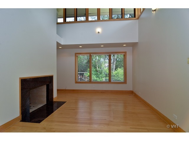 115 Dickens Road Northfield, IL 60093 - Photo 8 of 25 a view of a hallway with wooden floor and a fireplace