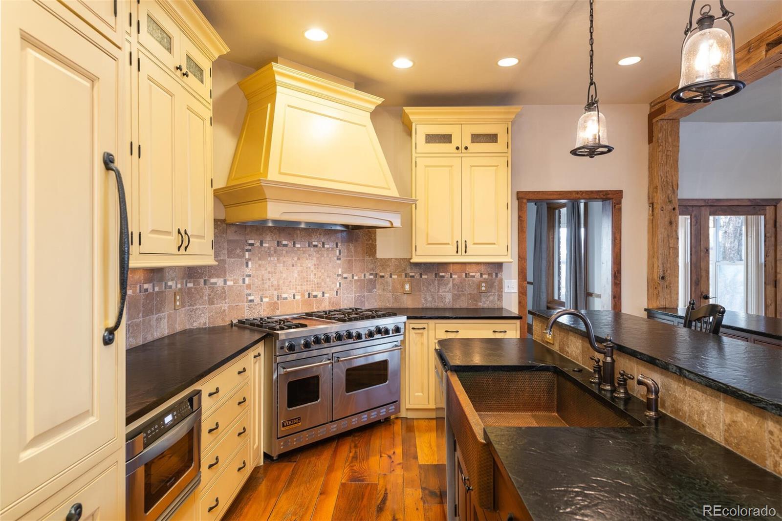 9905 Isabelle Road Lafayette, CO 80026 - Photo 23 of 38 a kitchen with stainless steel appliances granite countertop a stove a sink and a refrigerator
