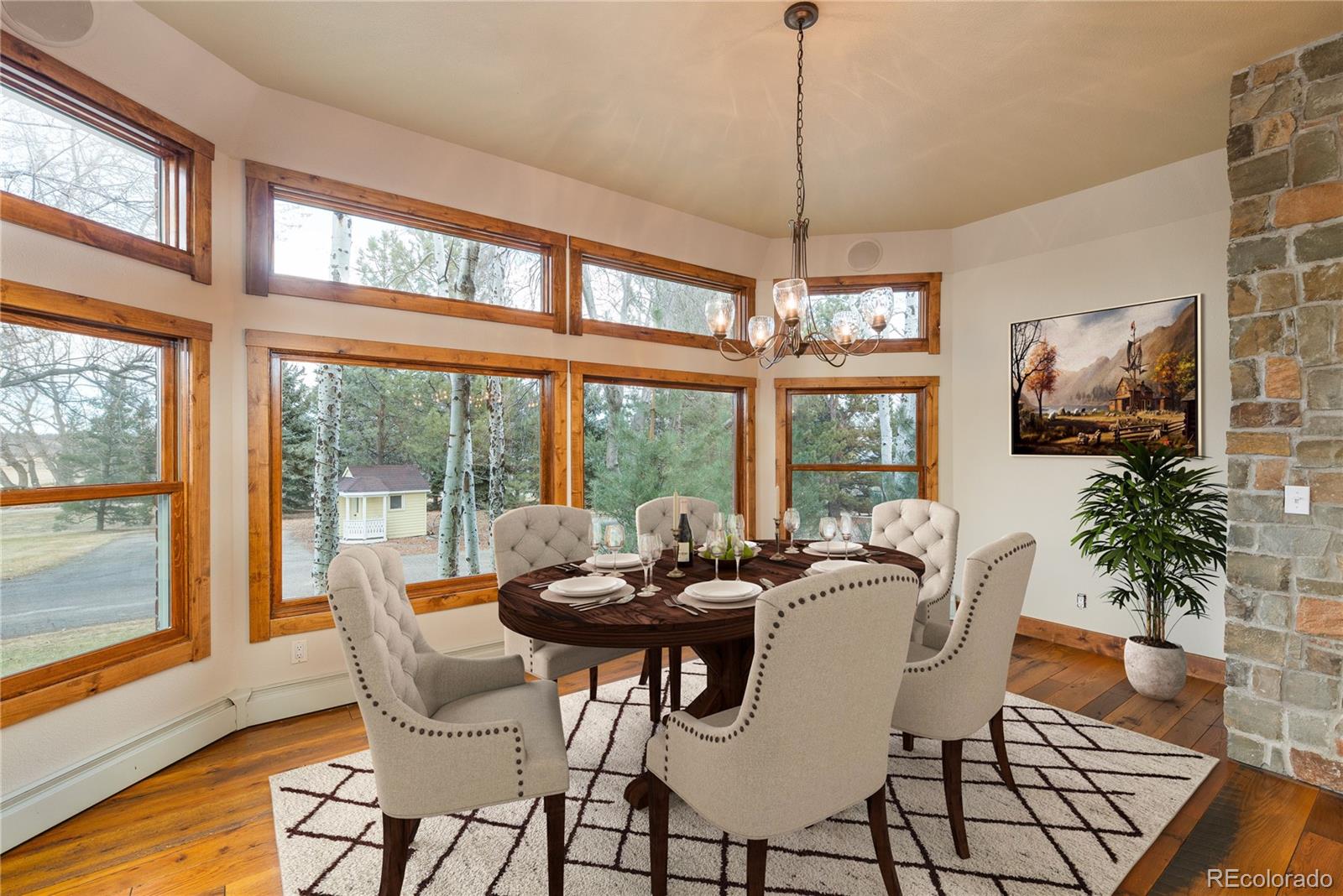 9905 Isabelle Road Lafayette, CO 80026 - Photo 25 of 38 a dining room with furniture large windows a chandelier and wooden floor