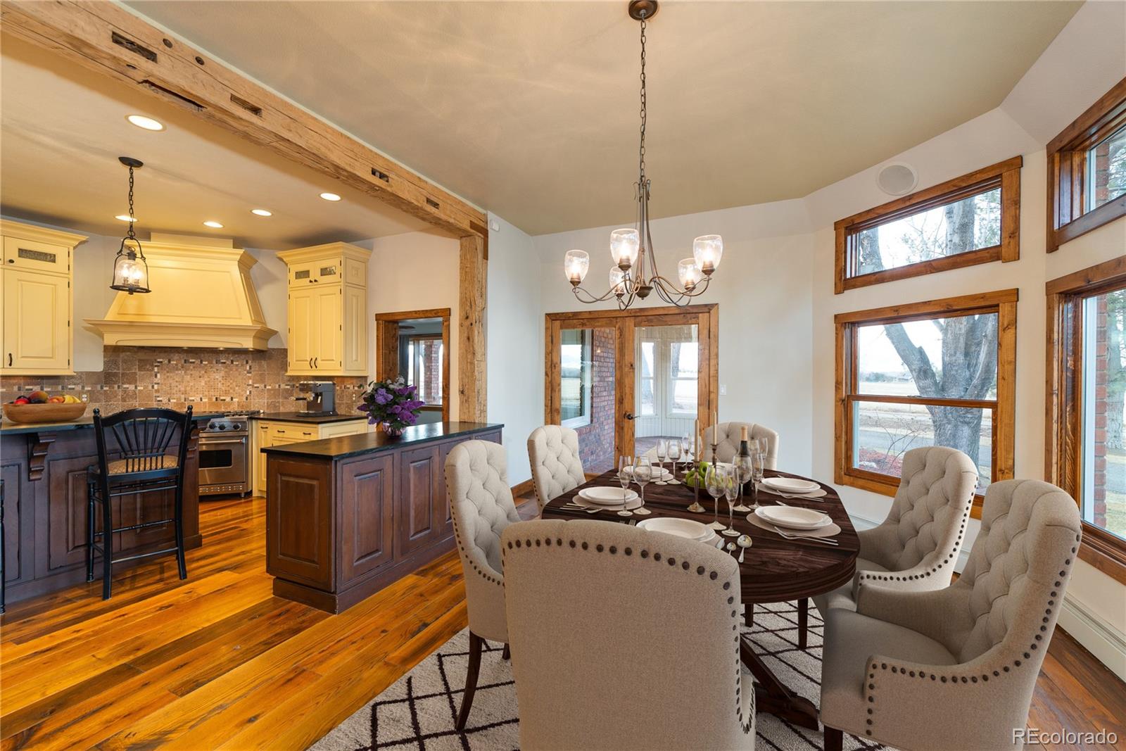 9905 Isabelle Road Lafayette, CO 80026 - Photo 26 of 38 a view of a dining room with furniture a chandelier and wooden floor