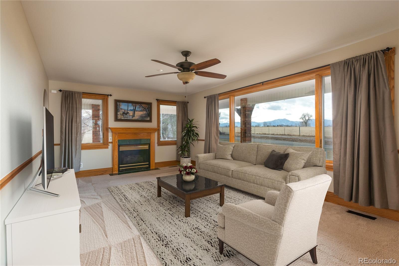 9905 Isabelle Road Lafayette, CO 80026 - Photo 28 of 38 a living room with furniture a large window and a flat screen tv