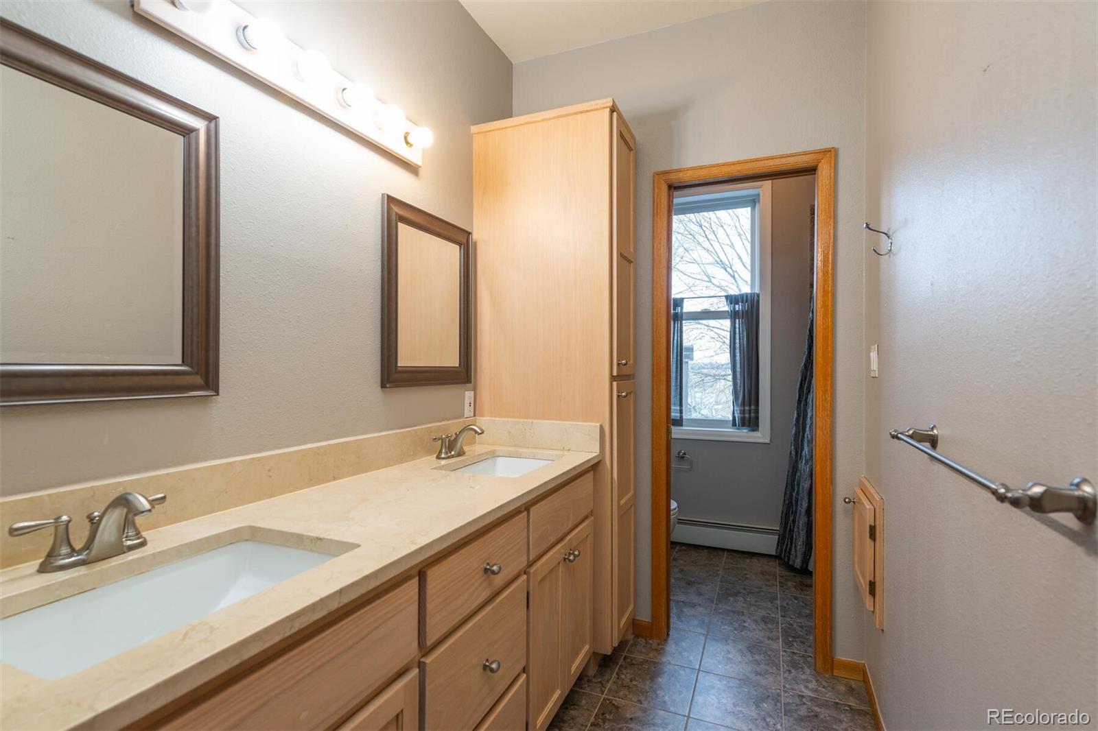 9905 Isabelle Road Lafayette, CO 80026 - Photo 34 of 38 a bathroom with a granite countertop sink mirror and double