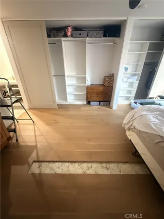a view of walk in closet with clothes and shoes