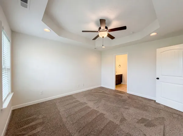 an empty room with fan and windows