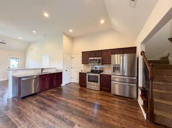 a kitchen with stainless steel appliances kitchen island granite countertop a refrigerator stove and oven