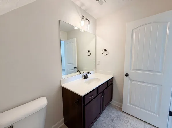 a bathroom with a sink toilet and mirror