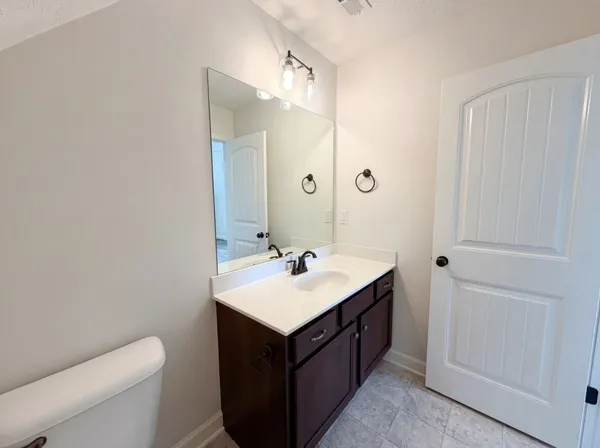 a bathroom with a sink vanity mirror and toilet