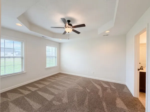 a view of a big room with windows and chandelier fan