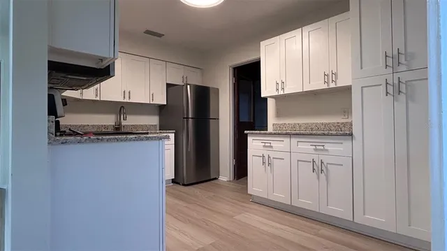 a kitchen with white cabinets and stainless steel appliances