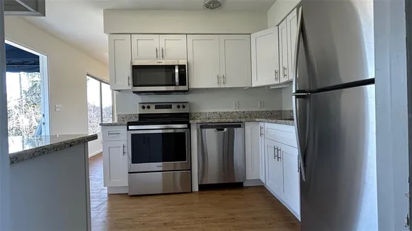 a kitchen with stainless steel appliances granite countertop a refrigerator and a stove top oven