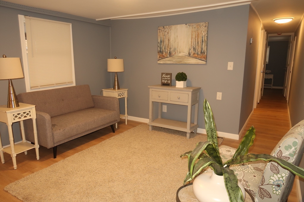 229 Miller Street, Unit 3G Ludlow, MA 01056 - Photo 5 of 15 a living room with furniture a fireplace and a table