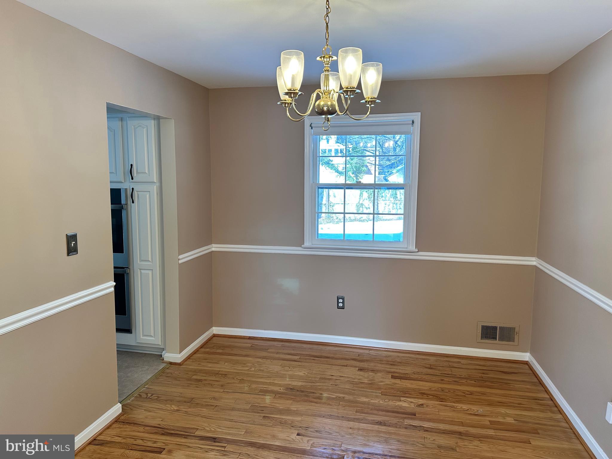 4405 Bel Pre Road Rockville, MD 20853 - Photo 4 of 24 a view of empty room with wooden floor and chandelier
