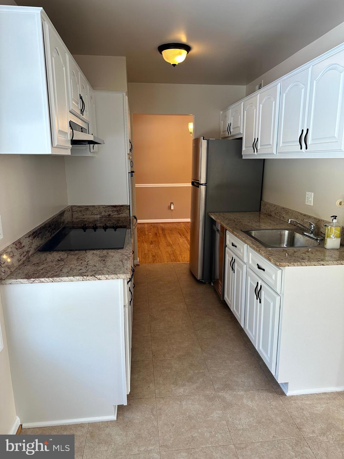 4405 Bel Pre Road Rockville, MD 20853 - Photo 6 of 24 a kitchen with granite countertop a sink a stove and cabinets