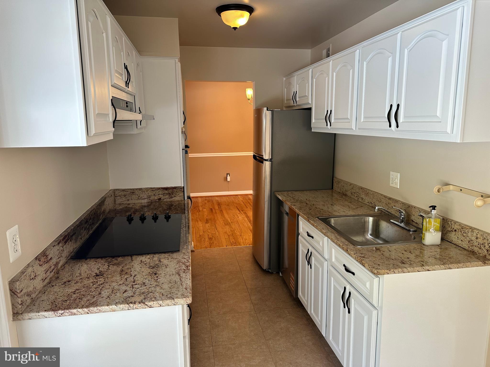 4405 Bel Pre Road Rockville, MD 20853 - Photo 7 of 24 a kitchen with granite countertop a sink a stove and a refrigerator