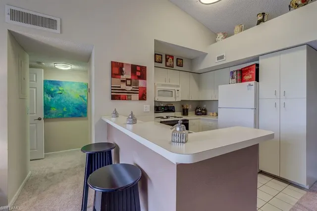 a kitchen with a sink a stove and chairs