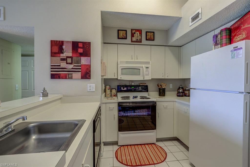 13545 Eagle Ridge Drive, Unit 827 Fort Myers, FL 33912 - Photo 16 of 27 a kitchen with stainless steel appliances a refrigerator sink and stove