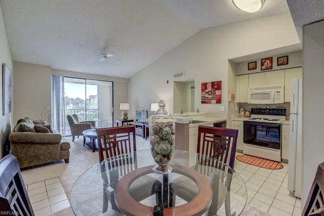 a living room with furniture a large window and a dining table