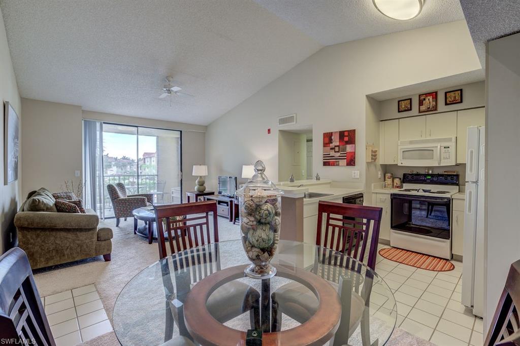 13545 Eagle Ridge Drive, Unit 827 Fort Myers, FL 33912 - Photo 18 of 27 a living room with furniture a large window and a dining table