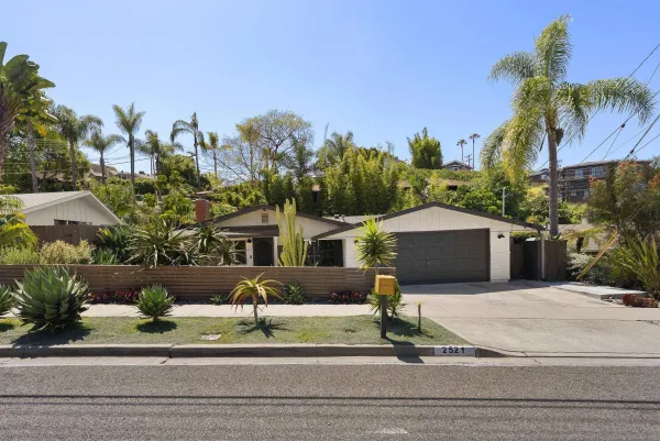 a front view of a house with a garden and plants