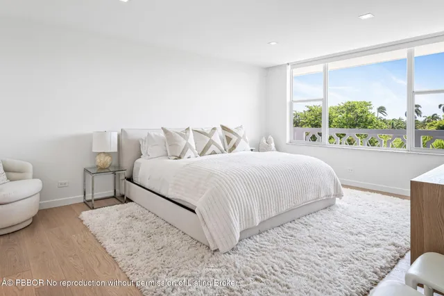 a bedroom with a bed and a large window