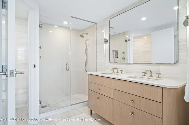 a bathroom with a double vanity sink mirror and shower