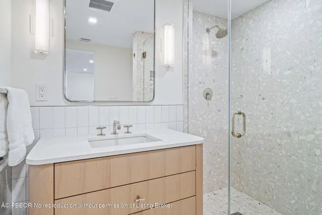 a bathroom with a sink a shower and a mirror
