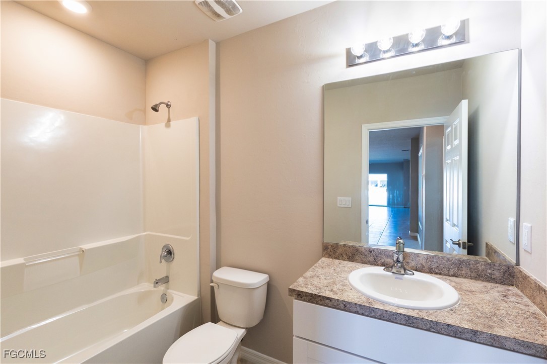 10749 Crossback Lane Lehigh Acres, FL 33974 - Photo 9 of 21 a bathroom with a granite countertop sink toilet and shower