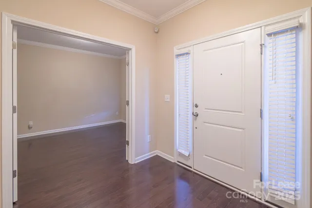 an empty room with wooden floor closet and windows