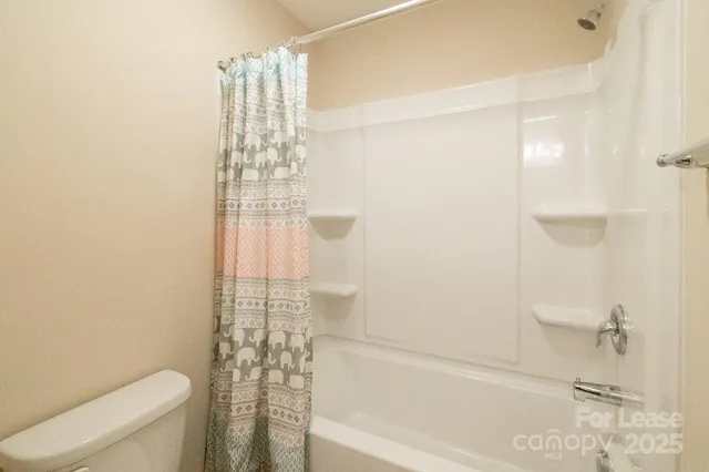 a bathroom with a shower curtain and a toilet