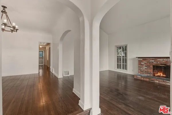 a view of empty room with wooden floor and fireplace