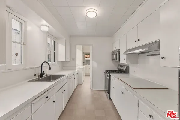 a kitchen with granite countertop a sink and cabinets