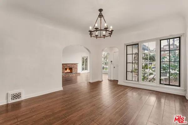 a view of a livingroom with wooden floor and windows