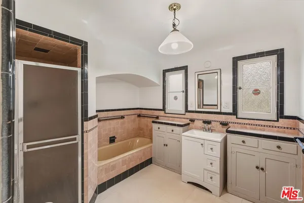 a bathroom with a tub sink and mirror