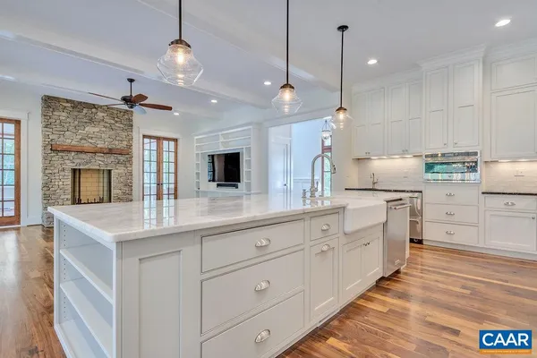 a kitchen with white cabinets and sink