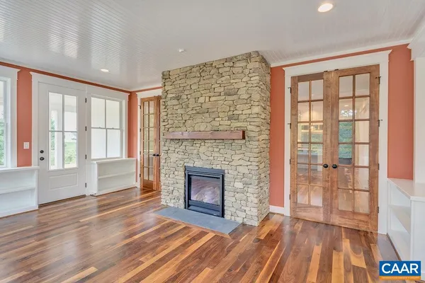 a view of empty room with wooden floor and fireplace
