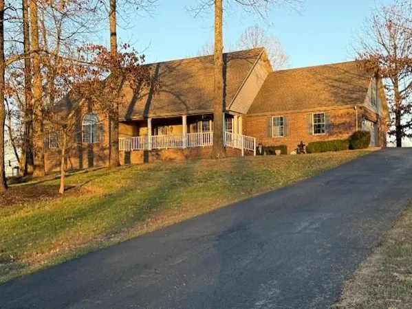 a view of an house with backyard and road