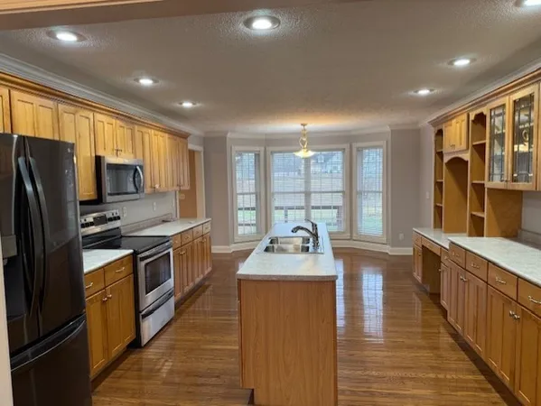 a kitchen with sink a refrigerator and wooden cabinets