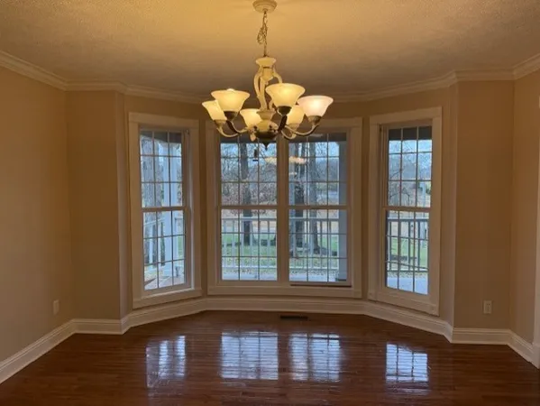 a view of a room with wooden floor and chandelier