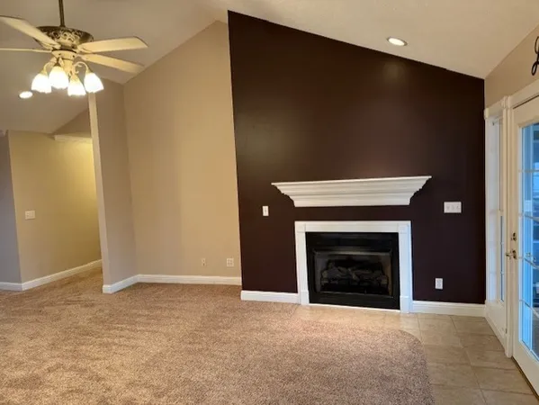 a view of empty room with fireplace and fan