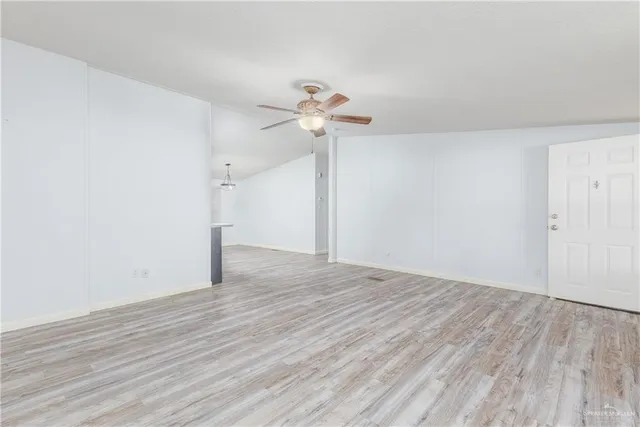 a view of a room with wooden floor and a ceiling fan