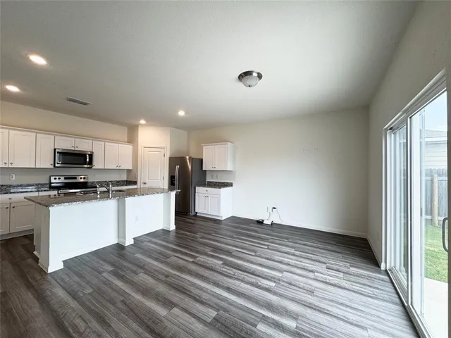 an empty room with kitchen and window