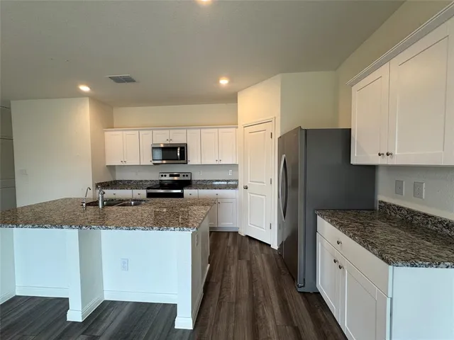 a view of kitchen with sink microwave refrigerator and stove