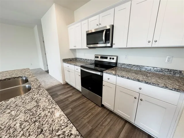 a kitchen with stainless steel appliances granite countertop a refrigerator stove microwave and sink