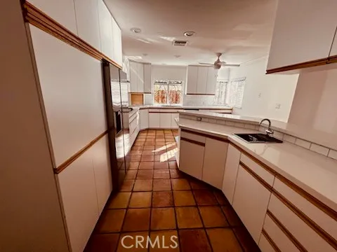 a kitchen with a sink a refrigerator a stove top oven and cabinets